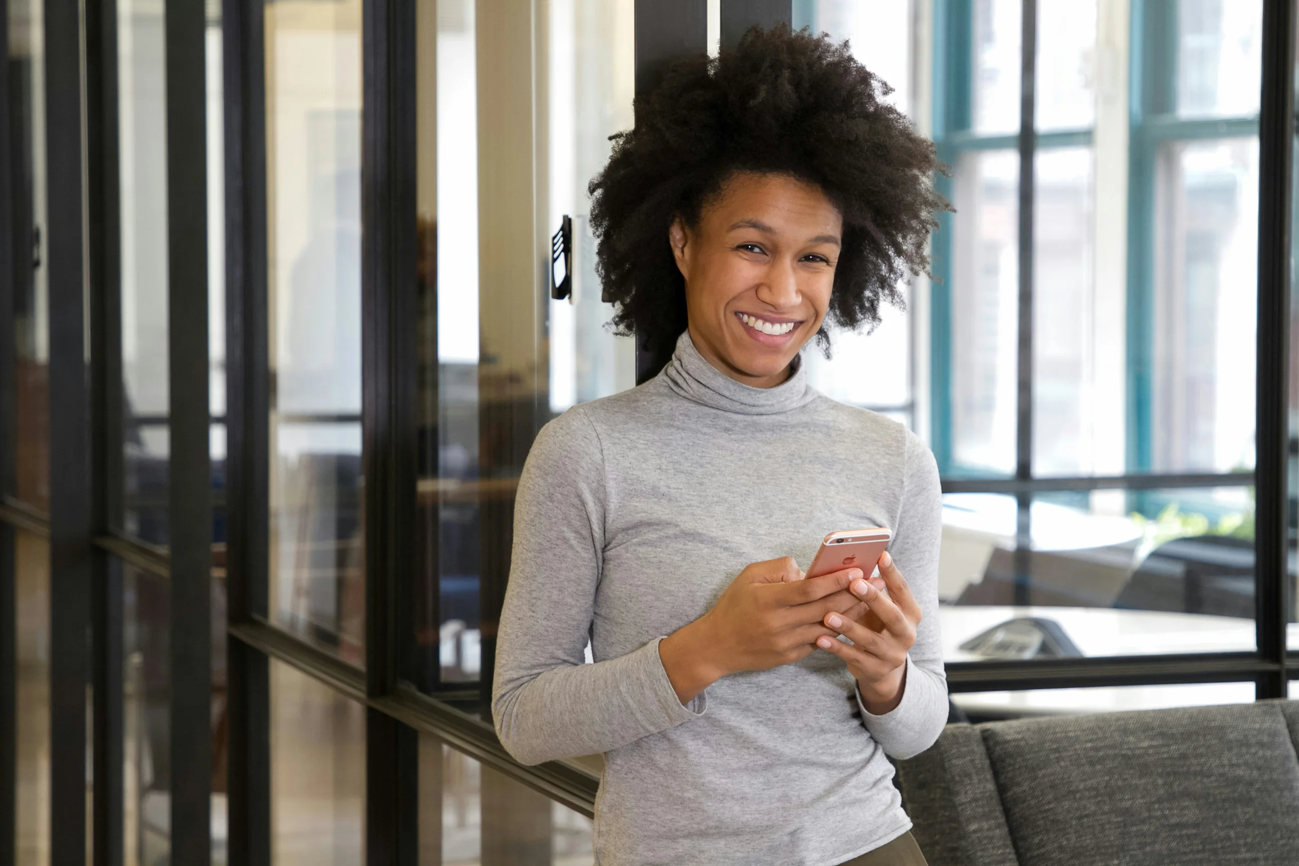 Une femme souriante travaillant sur son téléphone portable